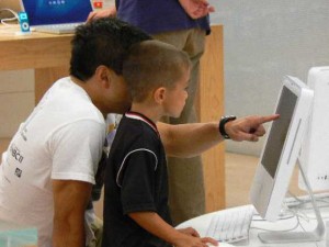 Fotografia di un babbo che insegna al figlio ad usare il computer